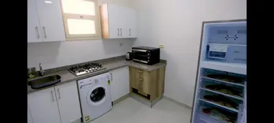 a small kitchen with a washer and a microwave at La bonita compound in Hurghada