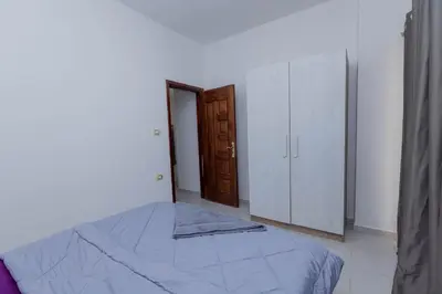 a bedroom with a bed and a closet and a door at La bonita compound in Hurghada