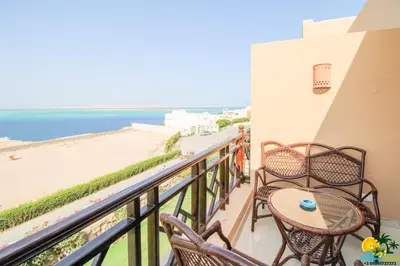 a balcony with a table and chairs and the beach at Bellevue The View in Hurghada