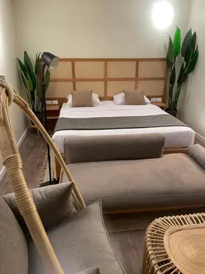 a bedroom with two beds and a chair and a table at Suite 69 in Hurghada