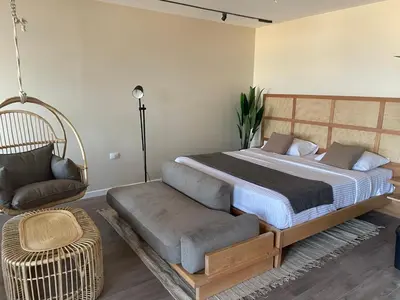 a bedroom with a large bed and a chair at Suite 69 in Hurghada