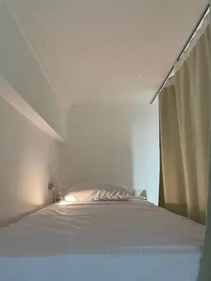 a white bed in a white bedroom with a window at Serafy City Center Hostel for Foreigners Adults Only in Hurghada