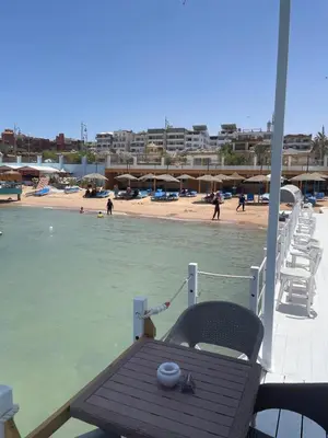 a boat with a table and chairs on a beach at Serafy City Center Hostel for Foreigners Adults Only in Hurghada