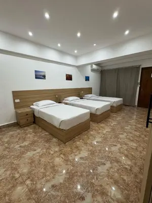 a room with three beds in a room at Lilly Stays Sheraton Road in Hurghada