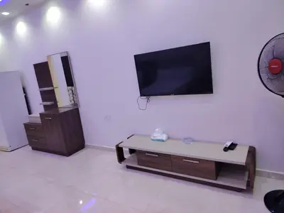 a living room with a flat screen tv on a wall at Selina Apartments in Hurghada