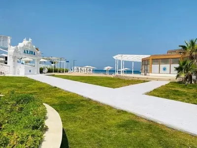 a walkway leading to a white house and the ocean at Selina Apartments in Hurghada