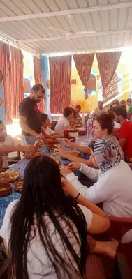 a group of people sitting at a long table at Kamel House in Aswan