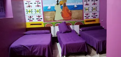 a room with purple beds and a painting on the wall at Kamel House in Aswan
