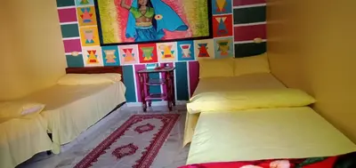 a room with two beds and a painting on the wall at Kamel House in Aswan