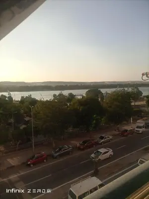 a view of a street with cars parked on the road at Aswan Nile view palace in Naj‘ al ‘Amrāb