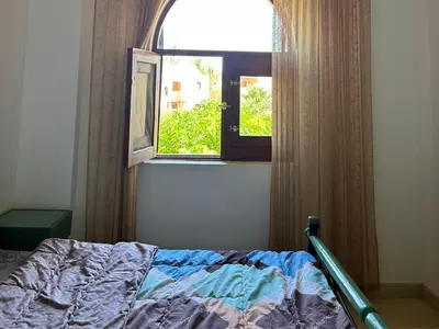 a bedroom with a bed and an open window at Hurghada Concierge in EL-Gouna in Hurghada