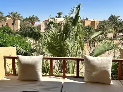 two white pillows sitting on a balcony with palm trees at Hurghada Concierge in EL-Gouna in Hurghada