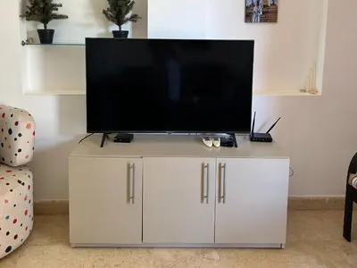 a flat screen tv sitting on top of a white cabinet at Hurghada Concierge in EL-Gouna in Hurghada
