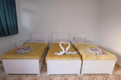 two beds in a room with two beds with towels at Luxor Nile View Flats in Luxor