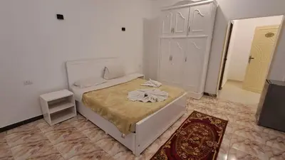 a small bedroom with a bed and a television at Luxor Nile View Flats in Luxor