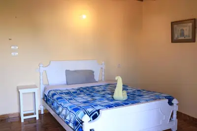 a bedroom with a white bed with a cat toy on it at Luxor Nile View Flats in Luxor
