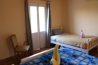 a small bedroom with two beds and a window at Luxor Nile View Flats in Luxor