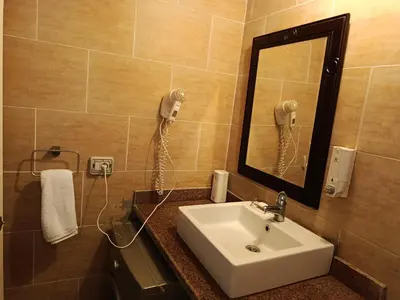 a bathroom with a sink and a mirror and a phone at Sunset pearl sahl hasheesh in Hurghada