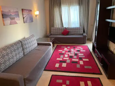 a living room with a couch and a red rug at Sunset pearl sahl hasheesh in Hurghada