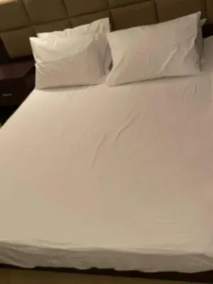 a bed with white sheets and pillows at Sunset pearl sahl hasheesh in Hurghada