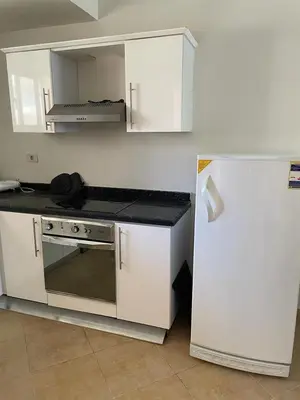a kitchen with a stove and a refrigerator at Sunset pearl sahl hasheesh in Hurghada
