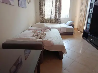 a room with two beds and a tv in it at Sunset pearl sahl hasheesh in Hurghada