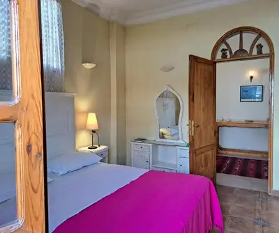 a bedroom with a bed and a dresser and a mirror at Villa Belzoni in Luxor