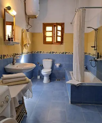 a bathroom with a tub and a toilet and a sink at Villa Belzoni in Luxor