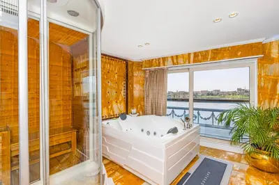 a bathroom with a tub and a window at Sonesta St George Nile Cruise - Luxor to Aswan 4 Nights from Monday to Friday in Luxor