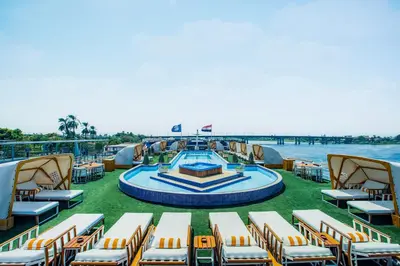 a deck of a cruise ship with chairs and a pool at Sonesta St George Nile Cruise - Luxor to Aswan 4 Nights from Monday to Friday in Luxor