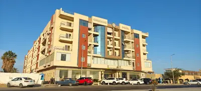 a building with cars parked in front of it at Casablanca Beach Direct sea view Tow Bedroom Apartment in Hurghada