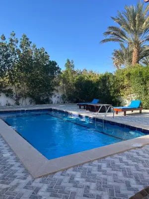 a swimming pool with a table and a bench at Villa Touristic Village Nr 7030 in Hurghada