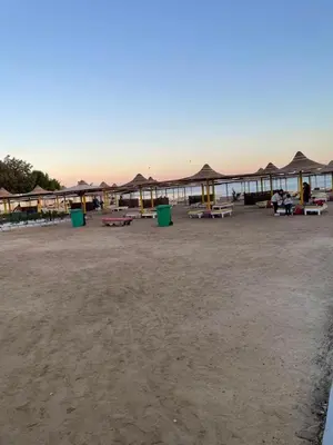 a group of tables and umbrellas on a beach at Villa Touristic Village Nr 7030 in Hurghada