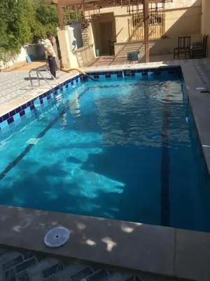 a large blue swimming pool with a person standing next to it at Villa Touristic Village Nr 7030 in Hurghada
