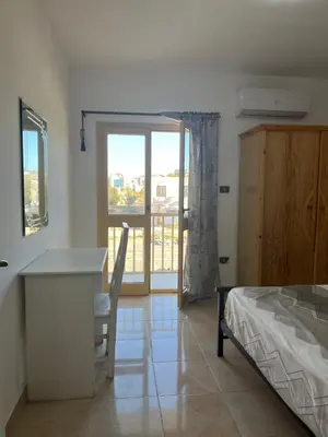 a bedroom with a bed and a desk and a window at Villa Touristic Village Nr 7030 in Hurghada