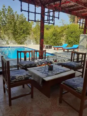 a table and chairs in front of a swimming pool at Villa Touristic Village Nr 7030 in Hurghada