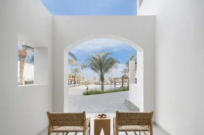 a room with two chairs and a table with a view of the beach at Serry Beach Resort in Hurghada