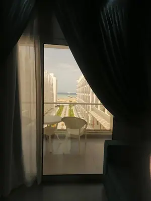 a room with a view of a balcony with a table and a window at Scandic Resort in Hurghada
