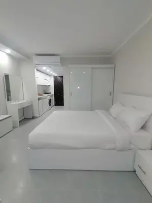 a white bedroom with a large bed and white cabinets at Scandic Resort in Hurghada