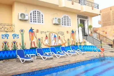 a group of chairs next to a swimming pool at Royal Mountain in Luxor