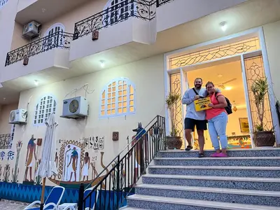 a man and woman standing on the stairs of a building at Royal Mountain in Luxor