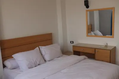 a bedroom with a bed with a mirror and a dresser at Royal Mountain in Luxor