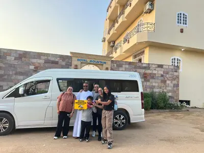a group of people standing in front of a van at Royal Mountain in Luxor