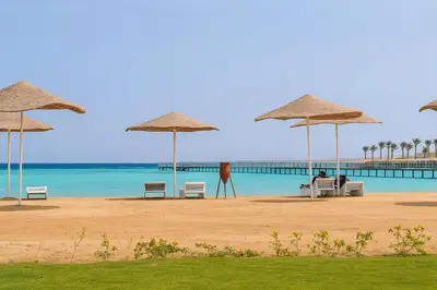 a beach with chairs and umbrellas and the ocean at Scandic Resort in Hurghada, EGYPT in Hurghada