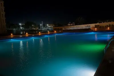 a swimming pool at night with blue and green illumination at Scandic Resort in Hurghada, EGYPT in Hurghada