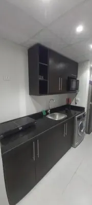 a black kitchen with a sink and a refrigerator at Scandic Resort: Comfy & Cozy. A433 in Hurghada
