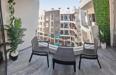 two chairs and a mirror in a room with a building at 3BR 2BA Retreat with Four Pools Gym and Onsite Dining Close to El Gouna in Hurghada