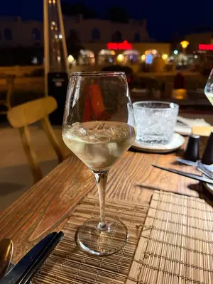 a glass of white wine sitting on a table at 3BR 2BA Retreat with Four Pools Gym and Onsite Dining Close to El Gouna in Hurghada