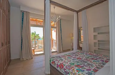 a bedroom with a canopy bed and a balcony at Soma Bay Seafront Luxury Appartement in Hurghada