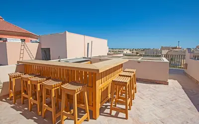a wooden bar with stools on a rooftop at Soma Bay Seafront Luxury Appartement in Hurghada